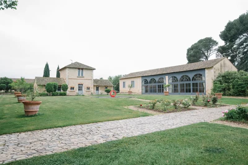 Estate courtyard with a paved path, terracotta jars and stone buildings