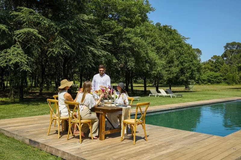 Meal set on the wooden deck beside the pool, beneath the trees