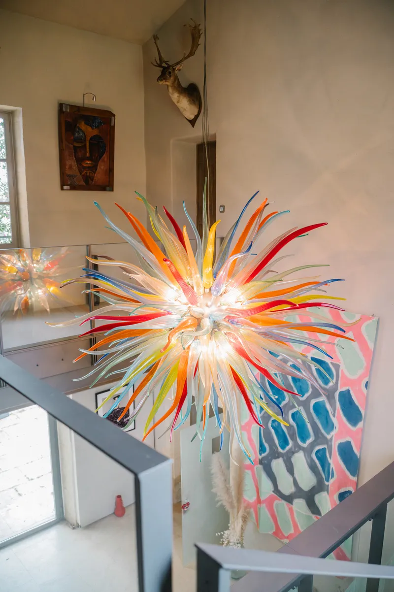 Multicoloured blown-glass chandelier above the staircase of a house