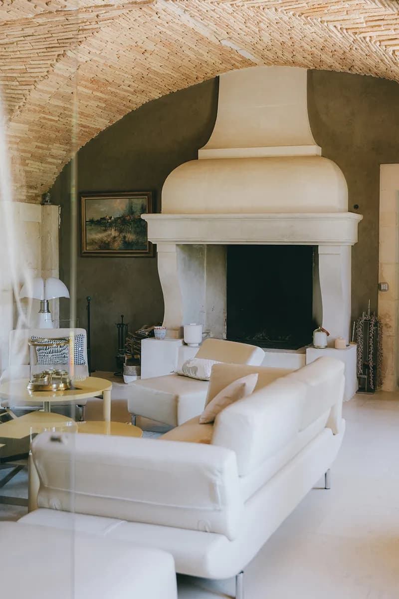 Brick-vaulted lounge with a large stone fireplace and white sofas
