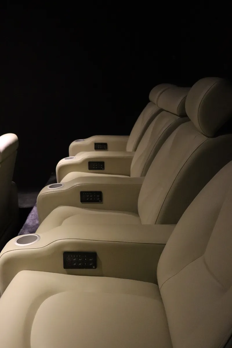 Reclining seats in a cinema room, with armrests and cup holders