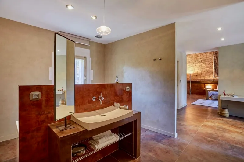 Shower room open to the bedroom, with a basin and a large mirror