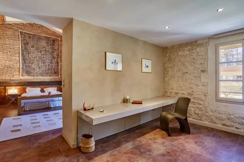 Desk area in a bedroom, with a floating worktop and a stone wall